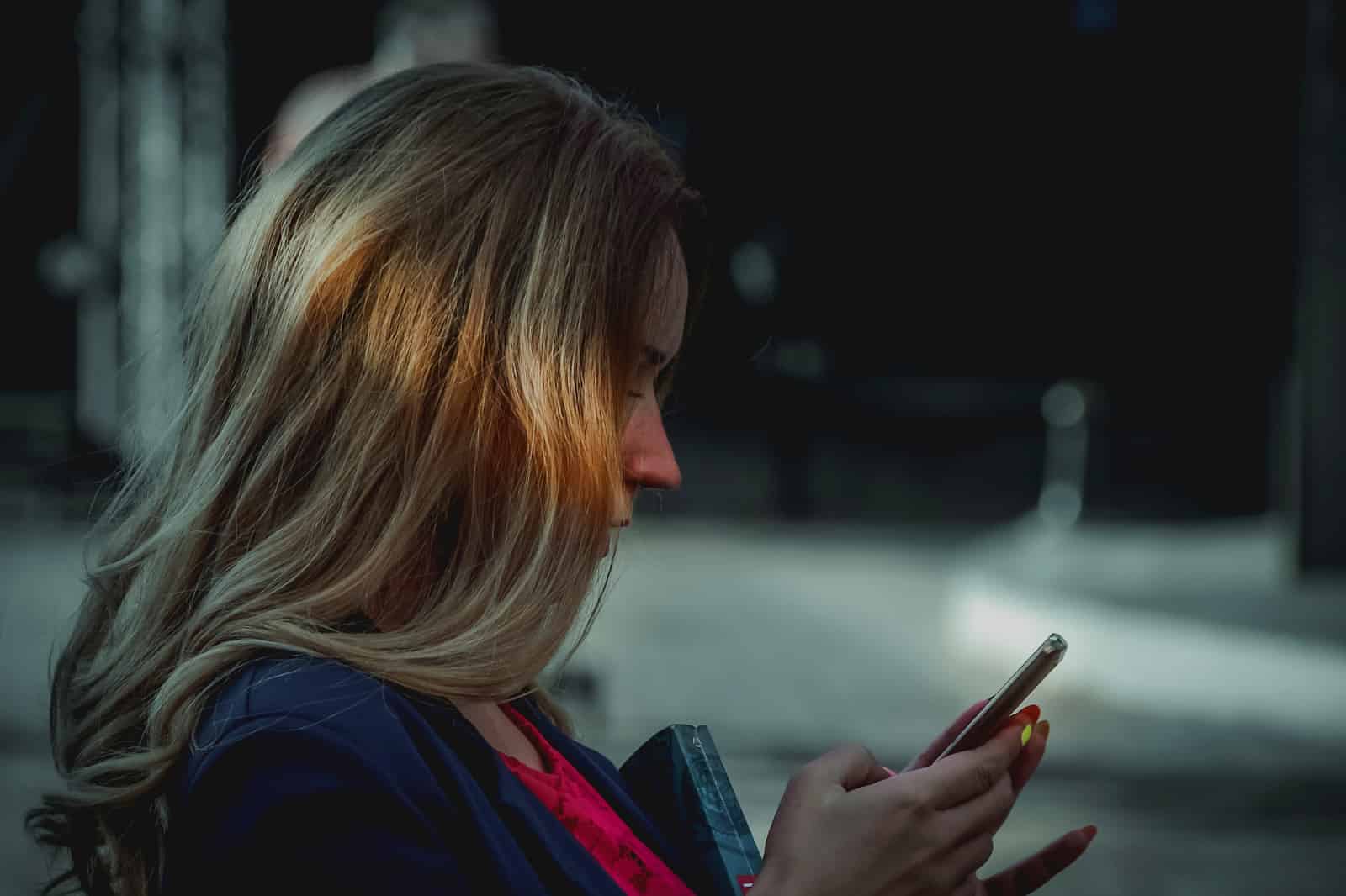 girl texting in the shadows